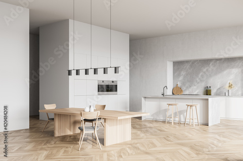 Modern contemporary design kitchen room interior. Dining table with chairs. Parquet flooring. White and wood material.