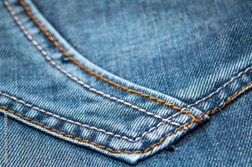 Background on the theme of denim clothing. Denim fabric with elements of seams.