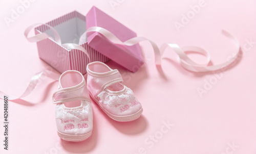 It’s a girl announcement. Baby girl pink shoes on pink color background. Baby shower, christening concept.