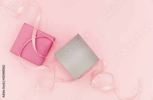 Girl birthday present concept. Gift box open and empty on pink background.