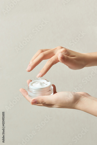 Closeup the hands of a beautiful woman using a nourishing cream jar in her hand. photo