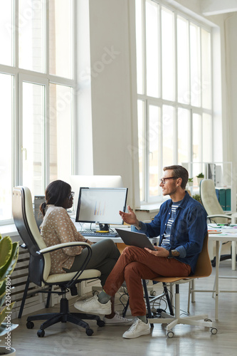 Project Manager Instructing Female Employee in Office