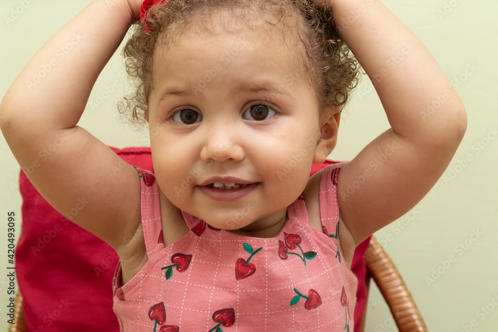 1 year old tormenter, with hands on her head and wearing a pink