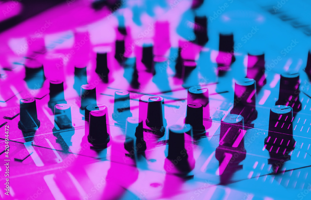 Dj sound mixer in neon lights.Professional disc jockey mixing controller on concert stage.Audio equipment in nightclub Dj sound mixer in neon lights.Professional disc jockey mixing controller on concert stage.Audio equipment in nightclub