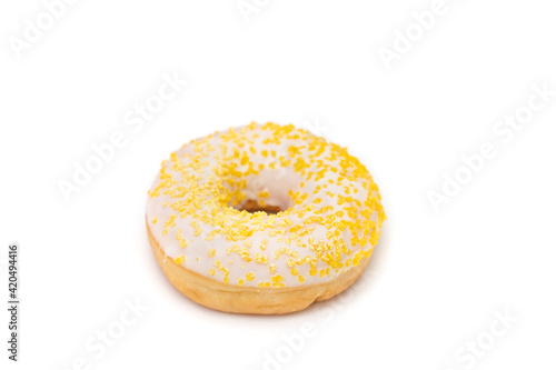 Donut with white sugar glazed and sprinkled with yellow pastry crumbs, on a isolated background with copy space