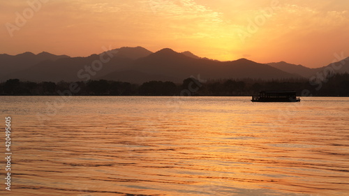 The beautiful sunset view with the peaceful lake reflection and mountains as background