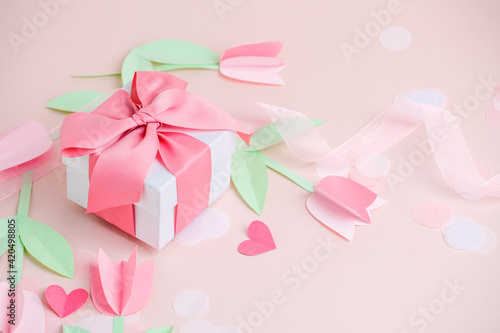 Holiday greeting card pink background with gift, Naive paper cut flowers tulips. Valentine's Day, Happy Women's Day, Mother's Day, Birthday, Wedding, space for text, foil baloon, stylish flyer, banner