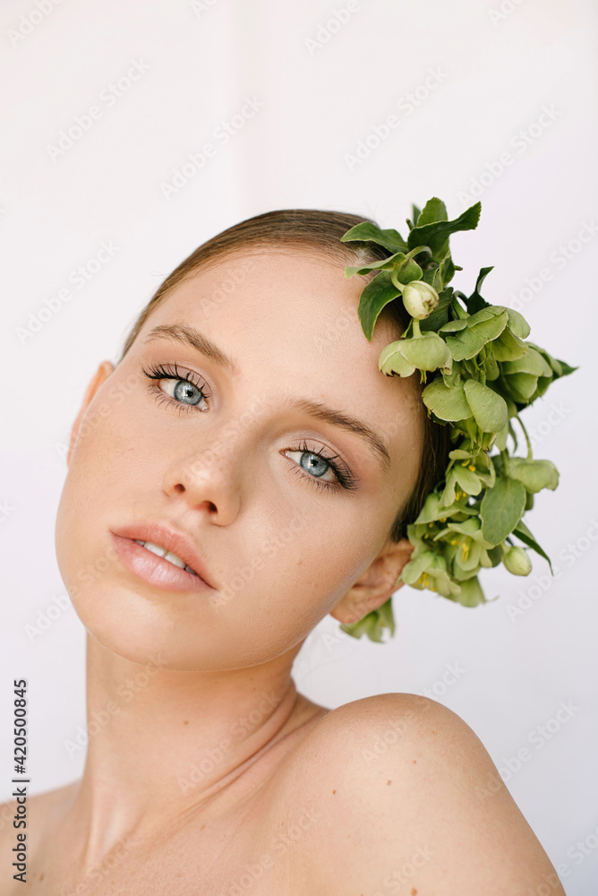 Sensual portrait of a young blue-eye's girl with flowers covering her head Sensual portrait of a young blue-eye's girl with flowers covering her head