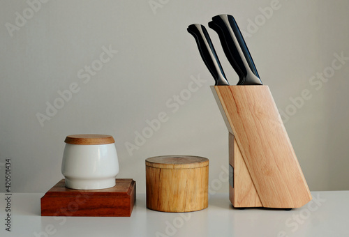set of knives on a wooden stand, salt shaker, wooden bowl on a white background