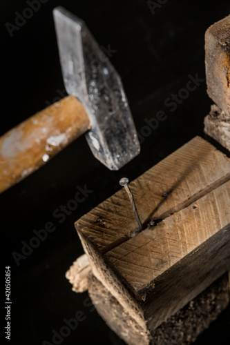 martello colpisce un chiodo dentro una tavola di legno