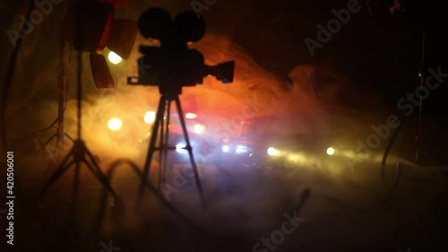 Action movie concept. Police cars and miniature movie set on dark toned background with fog. Police car chasing a car at night. Scene of crime accident. Selective focus