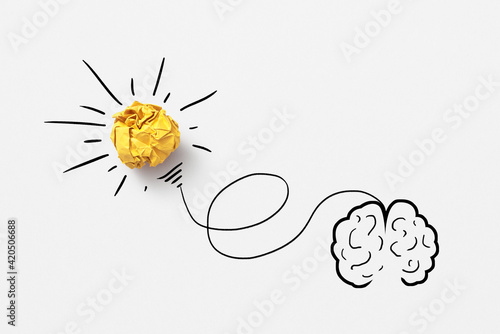 Sketch of human brain with lighting paper bulb.