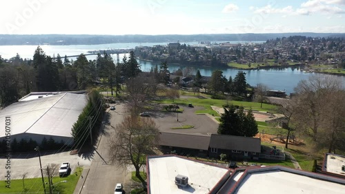 Cinematic aerial drone footage of Bremerton, Manette, Sinclair Inlet, Puget Sound Naval Shipyard, the downtown marina, ferry terminal and shops in the background in Kitsap County, Washington State photo