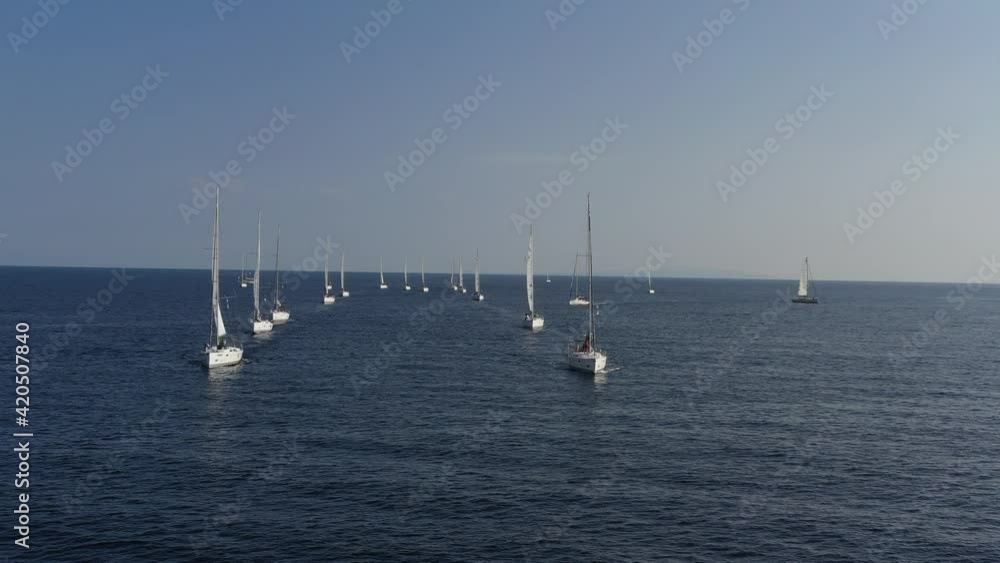 Ranks from yachts of participants of a regatta goes on a start point, is a sailing race at Croatia, reflection of sails on water, boat number aft boats Ranks from yachts of participants of a regatta goes on a start point, is a sailing race at Croatia, reflection of sails on water, boat number aft boats