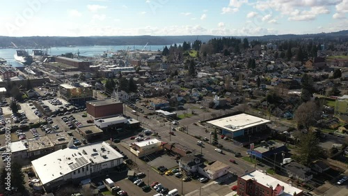 Cinematic birdseye shot of Bremerton, Manette, Sinclair Inlet, Puget Sound Naval Shipyard, the downtown marina, ferry terminal and shops in the background in Kitsap County, Washington State photo