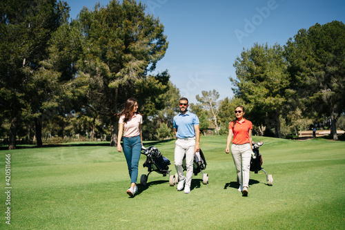 Golf players walking on lawn together photo