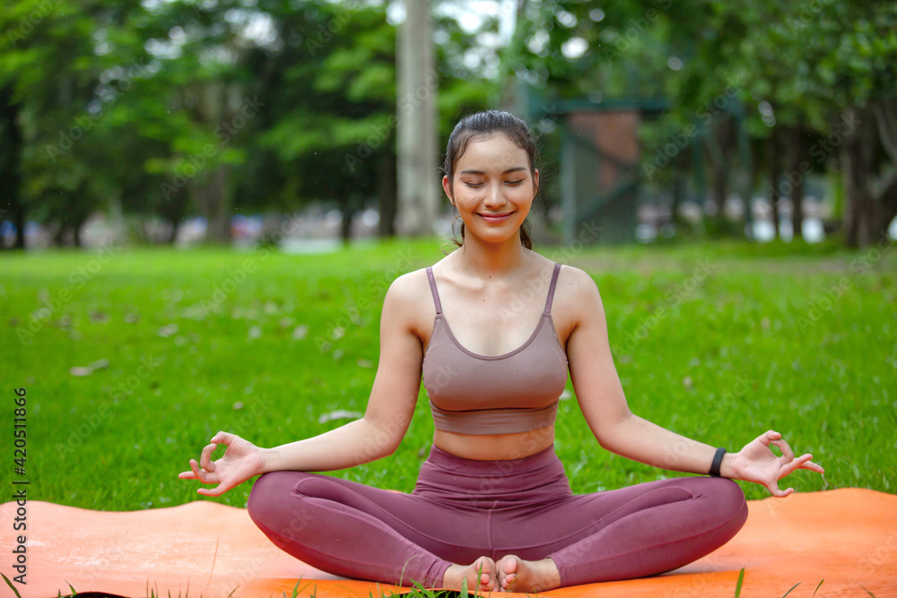 Beautiful woman doing morning exercises in exercise clothes and having clean water in bottles. On the green lawn in your front yard or park Beautiful woman doing morning exercises in exercise clothes and having clean water in bottles. On the green lawn in your front yard or park