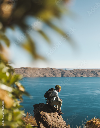 traveler sitting admiring the beauty of lake Titicaca photo