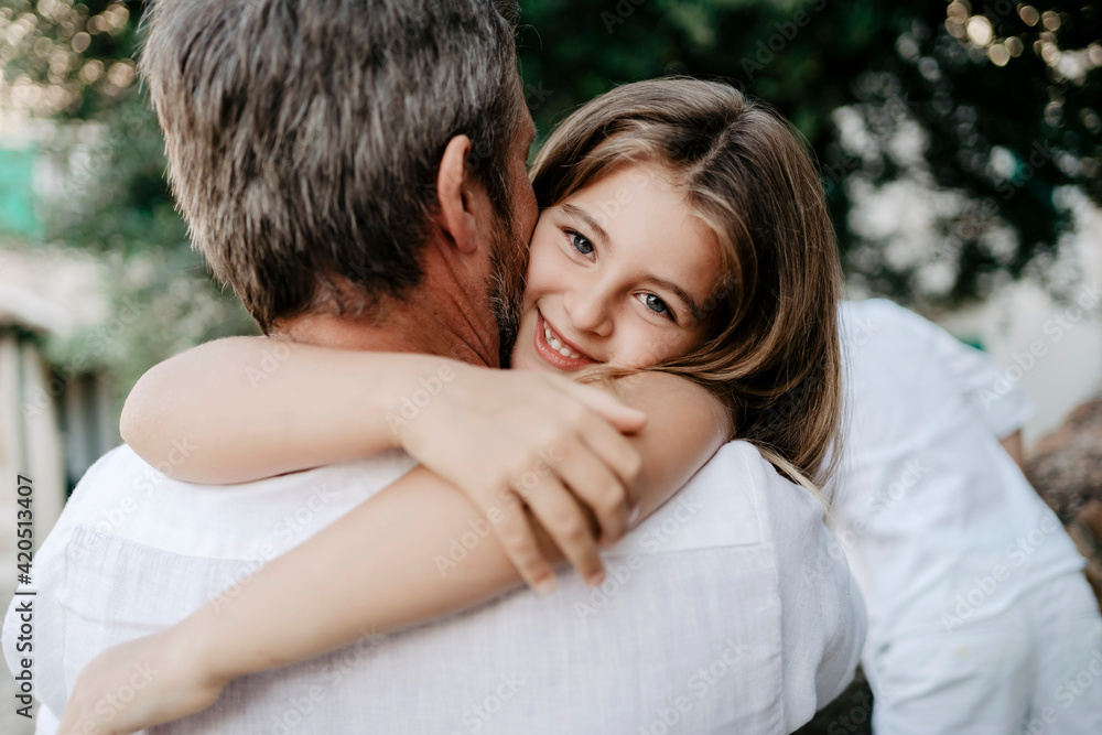 Portrait of a daughter embracing the father, during a day off outdoor in summer Portrait of a daughter embracing the father, during a day off outdoor in summer