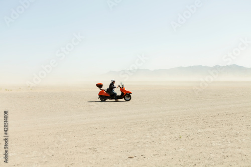 Man Driving a scooter in the desert photo