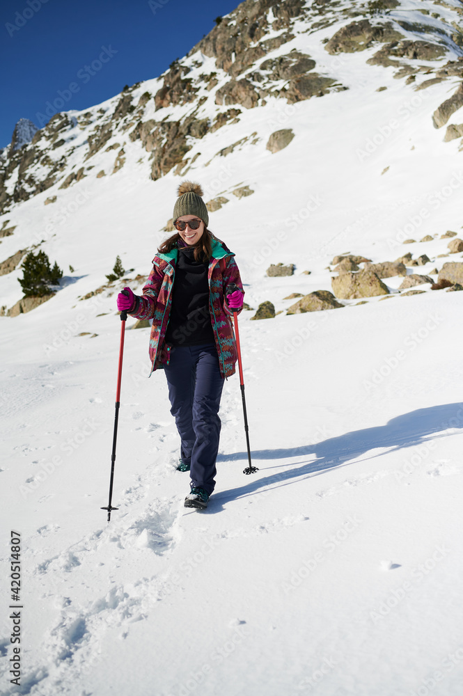 Cheerful woman walking in snowy mountains Cheerful woman walking in snowy mountains