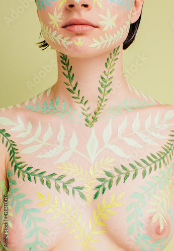 Unrecognizable model breast with leaves pattern on skin photo