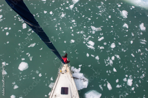 sailboat finding its way through icy water photo