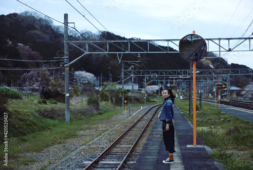 Asian woman, stop on the train track and look far away. Journey in Japan photo