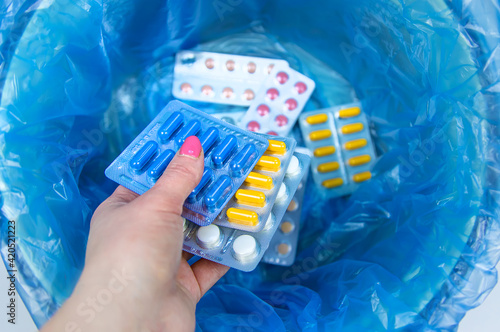 Throw away the tablets in the trash bin. Selective focus.