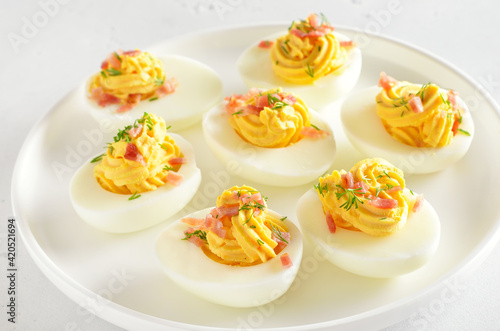 Stuffed eggs with egg yolk, bacon, mustard and dill