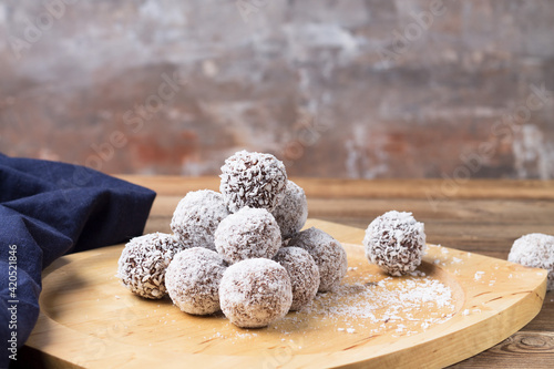 Coconut energy balls on a wooden tray, on a wooden table. photo