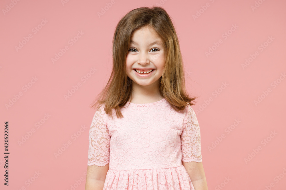Little toothy smiling cheery cute kid girl 5-6 years old wears rosy dress have fun isolated on pastel pink background child studio portrait. Mothers Day love family people childhood lifestyle concept Little toothy smiling cheery cute kid girl 5-6 years old wears rosy dress have fun isolated on pastel pink background child studio portrait. Mothers Day love family people childhood lifestyle concept
