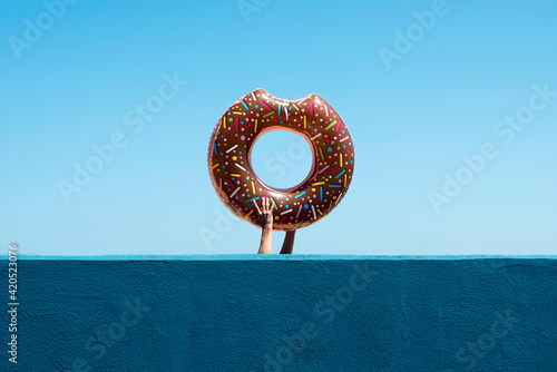 man carrying a donut-shaped swim ring photo