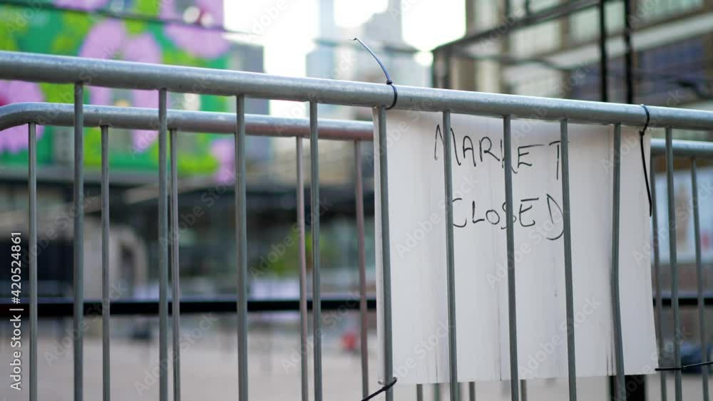 Empty and closed outdoor market during Covid-19 Coronavirus pandemic, closed sign, no people during lockdown, London city skyline in the background with high skyscrapers Empty and closed outdoor market during Covid-19 Coronavirus pandemic, closed sign, no people during lockdown, London city skyline in the background with high skyscrapers