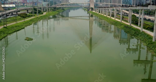 Cinematic establishing aerial shot of the Ponte Estaiada Bridge in Sao Paulo, Brazil. Tilt up reveal shot, slow push in. photo