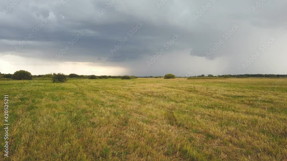 Panorama of dark storm clouds over summer meadow in the evening Panorama of dark storm clouds over summer meadow in the evening
