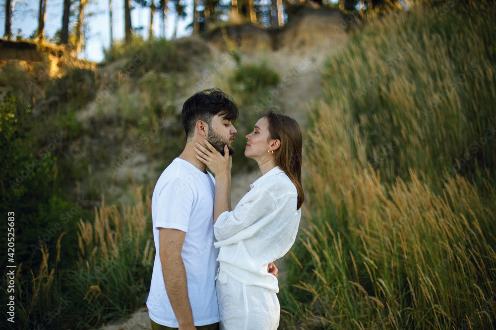 young woman touches the face of a bearded man with her hands and hugs him. romantic relationship. love story