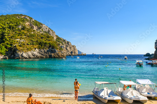 Fototapeta Naklejka Na Ścianę i Meble -  Tourists relax in the clear waters at the sandy Palaiokastritsa beach on the Aegean island of Corfu, Greece.