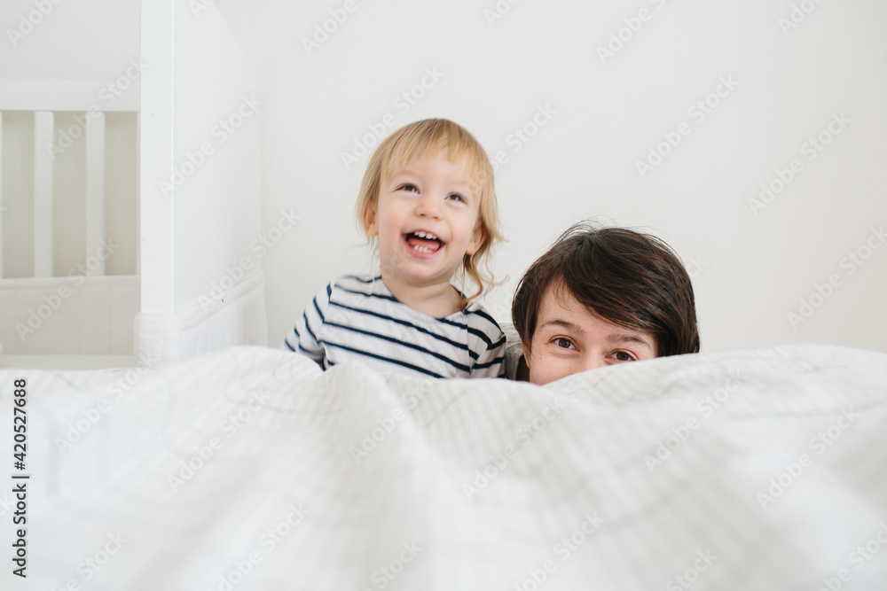 Mother and child peering out the bed Mother and child peering out the bed
