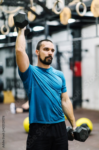 Muscular man exercising with dumbbell weights