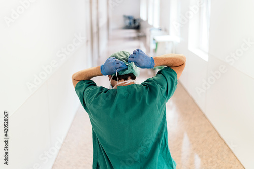 Unrecognizable doctor covering his face with mask
