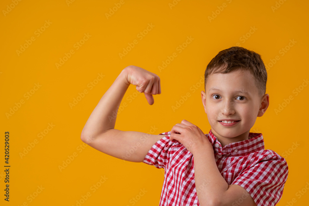 positive, confident Caucasian 8yearold in shirt smiles and raises his