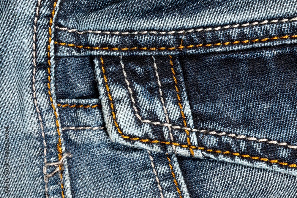 Jeans background. Denim fabric with seams close-up. Jeans background. Denim fabric with seams close-up.