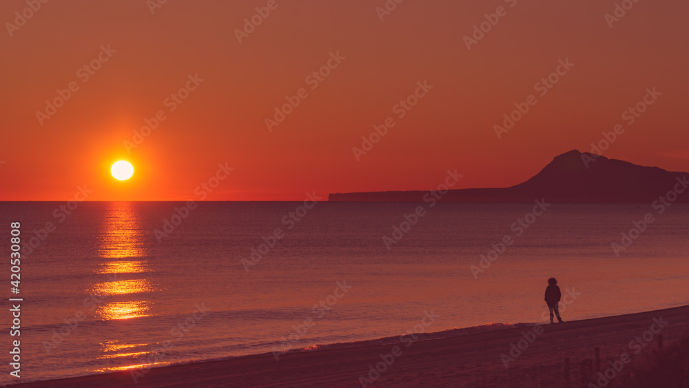 Person silhouette on beach enjoy sunrise