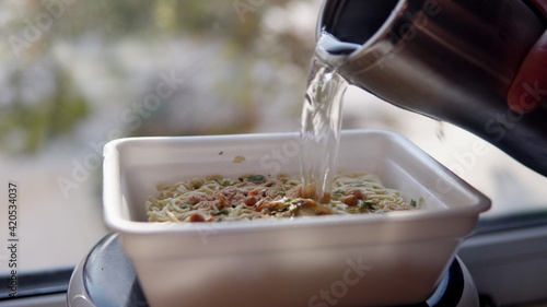 Slika na platnu Adding boiling water to the top ramen. Brewing instant noodles