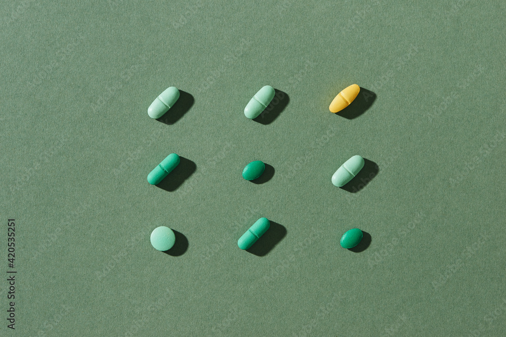 Different colorful pills on green background Different colorful pills on green background
