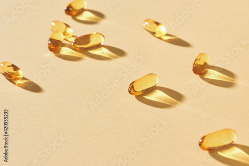 Omega-3 vitamins, fatty acids. Fish oil in yellow capsules on a yellow background.