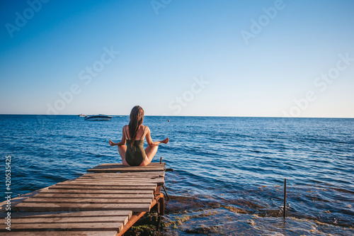 Young beautiful woman on yoga on the beach