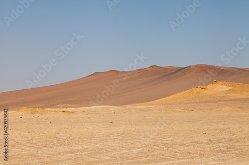 Landscape photography of red dunes and yellow sands, in the Paracas desert, on the Lagunillas Route, in the direction of Las Minas Beach in the Paracas National Reserve, Pisco, Ica, Peru.
