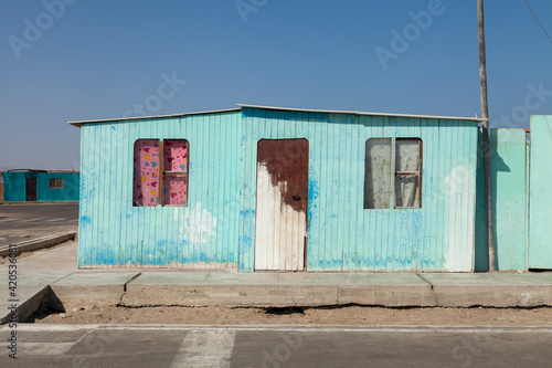 Example of a humble little house, inclined and slanted, typical dwelling painted in blue, of the local inhabitants of the city of Paracas, Pisco, Ica, Peru.